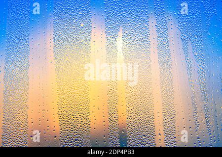 Water drops on the glass surface . Colorful wet surface with raindrops , Sunlight in the window Stock Photo