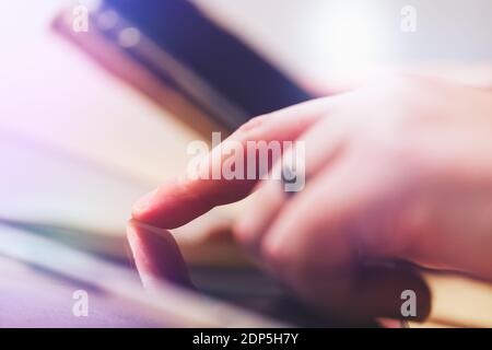 tap with a finger on a tablet and holding a smartphone in the other hand, technology Stock Photo