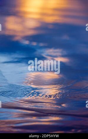 Yellow light reflected on blue water Stock Photo