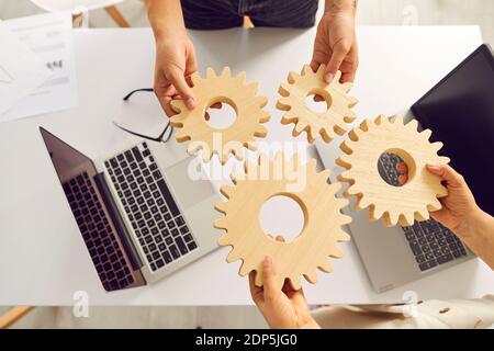 Business people joining cogwheels as metaphor for effective teamwork and finding optimal solution Stock Photo