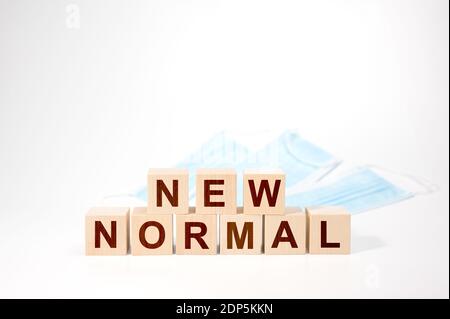 NEW NORMAL text on wooden cube. Wooden cubes with NEW NORMAL word. Adapting to new life or business post-lockdown after coronavirus pandemic. Business Stock Photo
