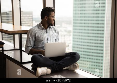 Smiling biracial man relax at home using laptop Stock Photo