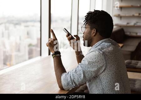 African American man use voice assistant on cellphone Stock Photo