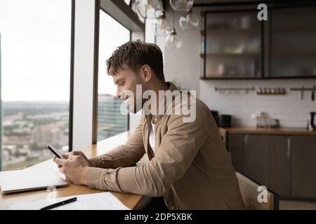 Smiling Caucasian man use smartphone in office Stock Photo