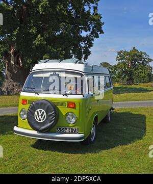 Classic Green and White Volkswagen - VW camper van park in  countryside setting. Stock Photo