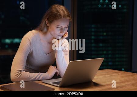 Female employee work on computer in office at night Stock Photo