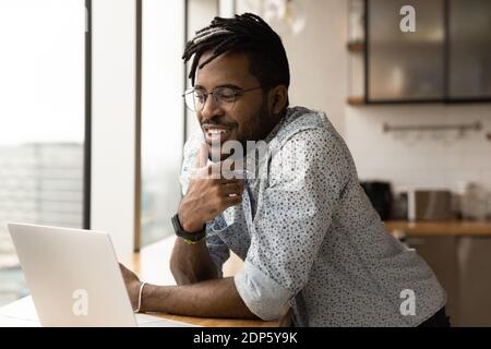 Smiling biracial man work online on laptop Stock Photo