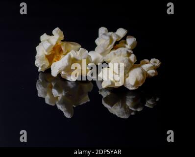 Popped popcorn isolated on black background. Reflection. Close up. Macro. Stock Photo