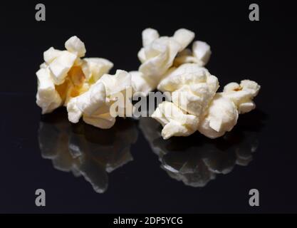 Popped popcorn isolated on black background. Reflection. Close up. Macro. Stock Photo