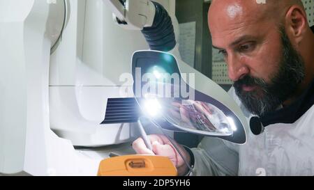 Electronics Engineer Works with on Robot. Stock Photo