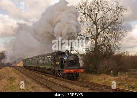 Drummond M7 Class 0-4-4T No. 53 heads south with the 13:47 (2C27) local service to Rothley, seen here passing through Woodthorpe. Stock Photo