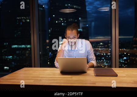 African American male employee work in office late hours Stock Photo
