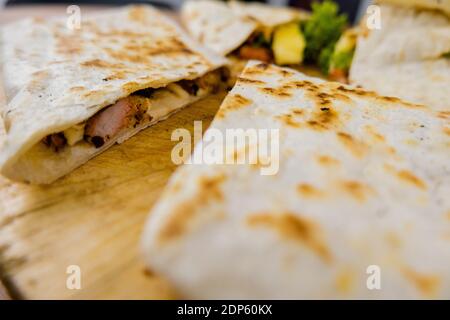 Meat quesadillas cut in half on a cutting board Stock Photo