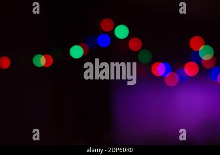 Abstract colored bokeh background of blurred lights garland on black background, for Christmas, New year and holidays Stock Photo