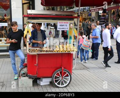 ISTANBUL,TURKEY-JUNE 7:Guy selling Roasted Chestnuts and Corns at Istiklal Street.June 7,2015 in Istanbul,Turkey. Stock Photo