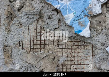 The texture of a gray wall with exposed reinforced mesh. Stock Photo