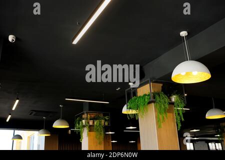 Ceiling lighting fixture lamps hanging along the curved in modern cafe Stock Photo