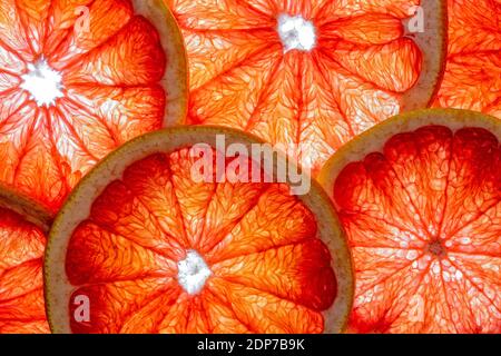 Pink grapefruit slices isolated on a white background with top view and structure. Healthy vegan food. Stock Photo