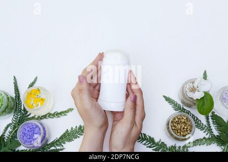 Hand holding deodorant antiperspirant fragrance flower , health care, flat lay style on white background Stock Photo