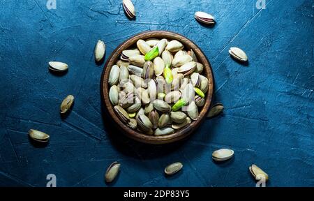 close-up of pistachios in wooden bowl, on black background Stock Photo