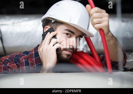 electrician contractor on the phone with cables Stock Photo