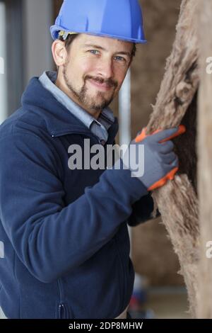 construction worker thermally insulating eco-wood frame house Stock Photo