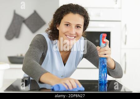 woman spraying houshold cleaner on kitchen counters Stock Photo