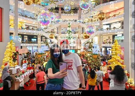 Kuala Lumpur, Malaysia. 19th Dec, 2020. People pose for photos in front of Christmas decorations at a shopping mall in Kuala Lumpur, Malaysia, Dec. 19, 2020. Credit: Chong Voon Chung/Xinhua/Alamy Live News Stock Photo