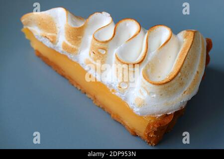 Closeup a Slice of Tasty Lemon Meringue Tart on Blue Plate Stock Photo