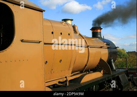 Old vintage locomotive steam railway train engine with smoke blowing from its chimney funnel , stock photo image Stock Photo