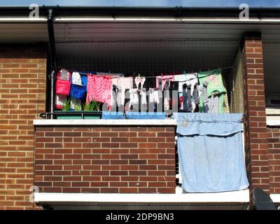 Washing hanging on a line on a balcony of a typical council flat apartment home in the heart of a deprived area of  London, England, stock photo image Stock Photo