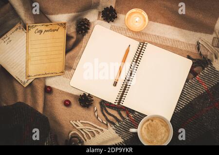 Home cozy atmosphere, copy space notebook with a pencil lies on a warm plaid, warm tones photo Stock Photo