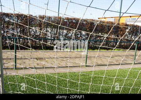 Closeup of a soccer goal net on a field of green artificial grass Stock Photo