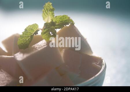 Homemade Indian paneer cheese made from fresh milk and lemon juice, diced in a wooden bowl on a gray stone background. Horizontal orientation. Stock Photo