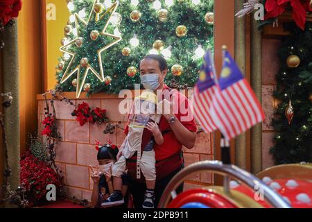 Kuala Lumpur, Malaysia. 19th Dec, 2020. A family poses for a photo in front of Christmas decoration at a shopping mall, amid the coronavirus crisis. The cumulative reported coronavirus (COVID-19) cases in Malaysia surpasses China. Credit: SOPA Images Limited/Alamy Live News Stock Photo