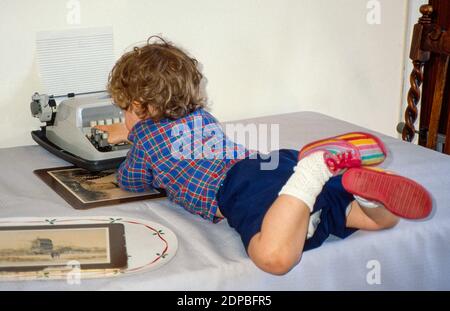 Boy tapping on a typewriter Stock Photo