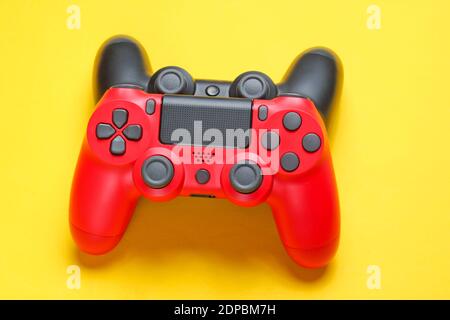 Red and black gamepad on yellow background close up Stock Photo