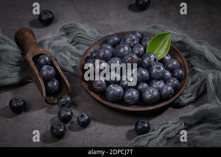 Dish with a bunch of blueberries on  dark background. Stock Photo
