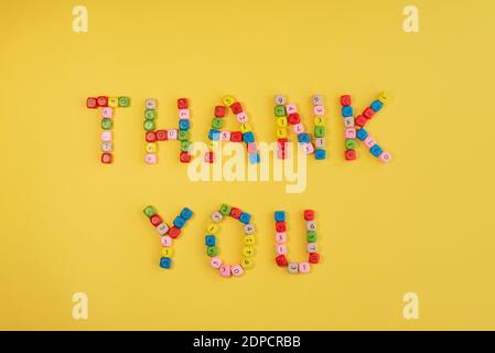 Thank you on bright yellow background. Words made of small colourful bricks with number. International Thank You day. Stock Photo