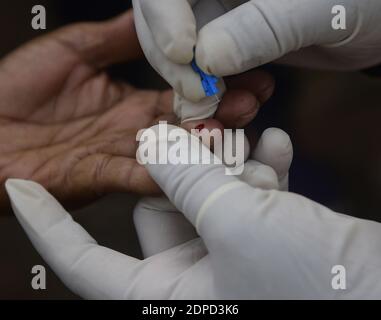 Health workers are testing blood of drivers from different commercial vehicles at a bus stand during a counselling and HIV test camp, organised by the Tripura State AIDS Control society.  Agartala, Tripura, India. Stock Photo