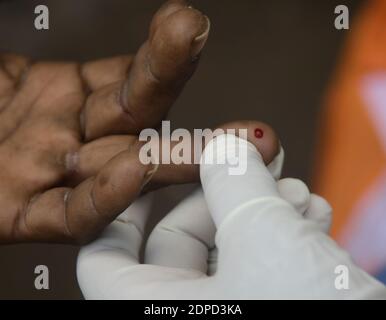 Health workers are testing blood of drivers from different commercial vehicles at a bus stand during a counselling and HIV test camp, organised by the Tripura State AIDS Control society.  Agartala, Tripura, India. Stock Photo