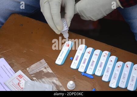 Health workers are testing blood of drivers from different commercial vehicles at a bus stand during a counselling and HIV test camp, organised by the Tripura State AIDS Control society.  Agartala, Tripura, India. Stock Photo