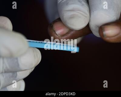 Health workers are testing blood of drivers from different commercial vehicles at a bus stand during a counselling and HIV test camp, organised by the Tripura State AIDS Control society.  Agartala, Tripura, India. Stock Photo