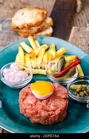 steak tartare with open egg on wood Stock Photo