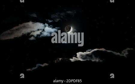 New Moon between clouds Stock Photo