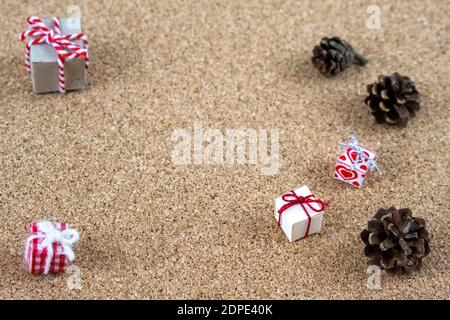 mini paper boxes concept mini Christmas boxes tiny Christmas gift boxes and pine cones with baker's twine and Scandinavian pattern on corkwood Stock Photo