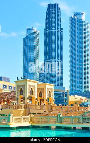 Dubai, UAE - January 30, 2020:  Bridge to main entrance of The Dubai Mall and modern towers in the background, United Arab Emirates