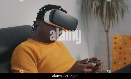 Virtual reality, african black man with VR headset using remote controller and playing games. High quality photo Stock Photo