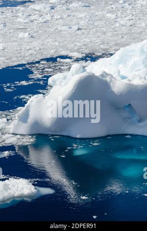 The bottom of an iceberg can be seen through the transparent glacial deep blue water of the Southern Ocean Stock Photo