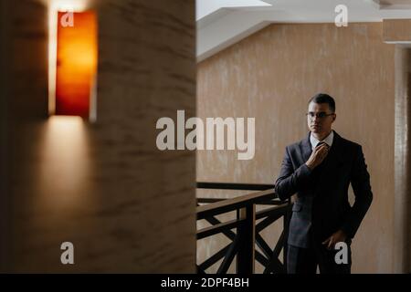 Portrait of the groom. The groom is expecting a meeting with the bride. Photoshoot of a successful businessman in a tuxedo. Stock Photo